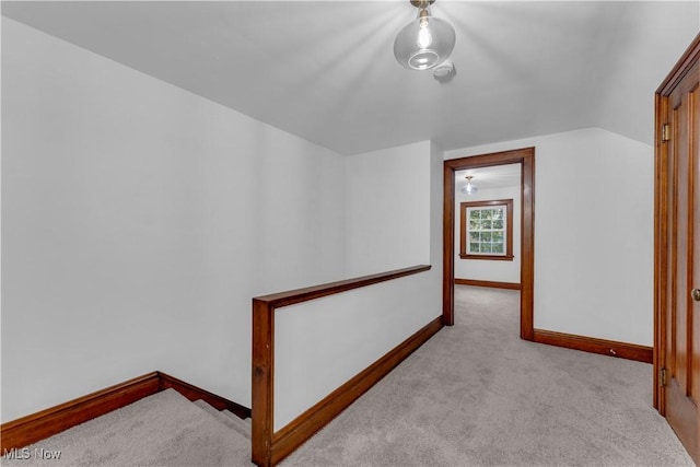 interior space featuring light carpet and vaulted ceiling