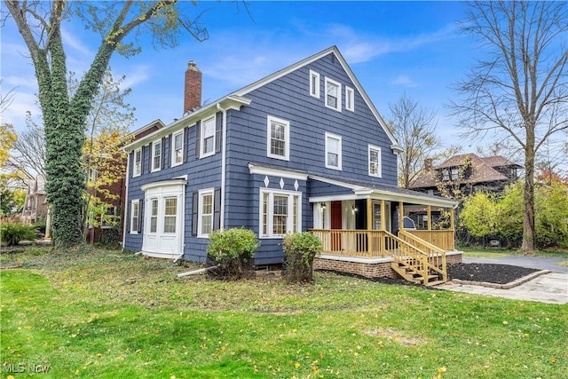 back of property featuring a porch and a yard