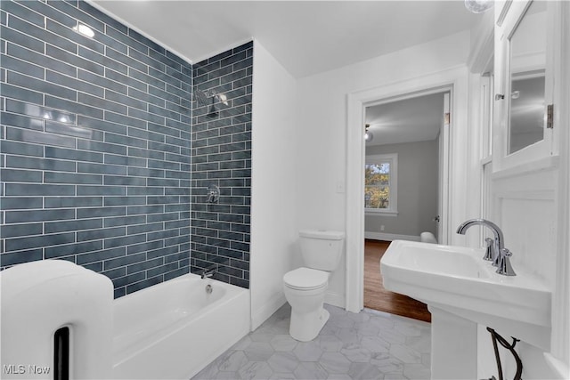 full bathroom with tiled shower / bath, tile patterned floors, toilet, and sink