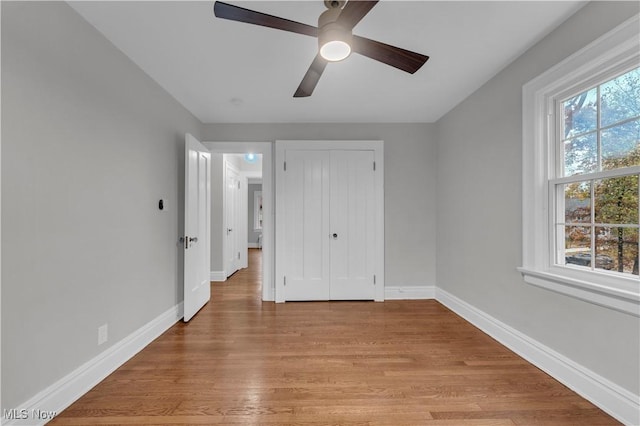 unfurnished bedroom featuring light hardwood / wood-style floors, a closet, and ceiling fan