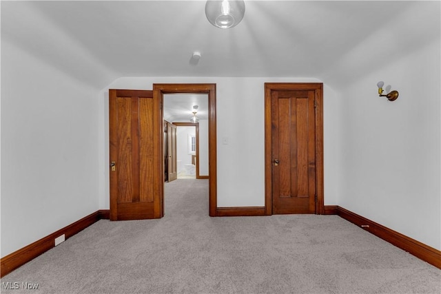 unfurnished bedroom featuring vaulted ceiling and light colored carpet