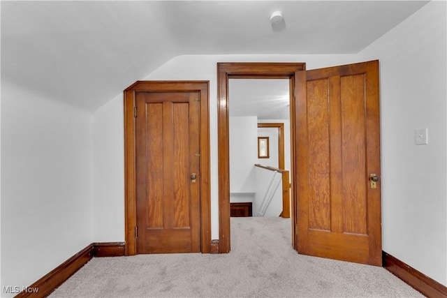 unfurnished bedroom with vaulted ceiling and carpet floors