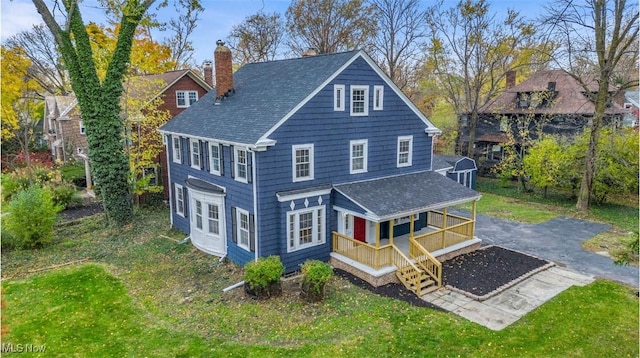 back of house with a yard and covered porch