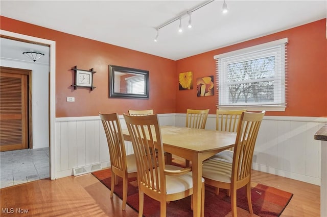 dining space featuring track lighting and light wood-type flooring