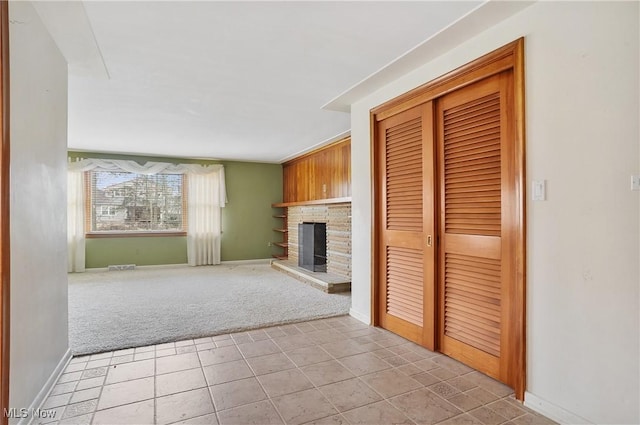 unfurnished living room featuring light carpet and a fireplace