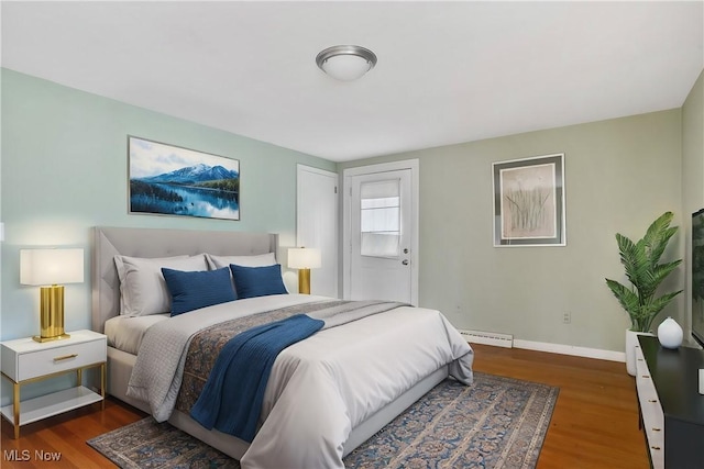 bedroom featuring a baseboard radiator and dark hardwood / wood-style flooring