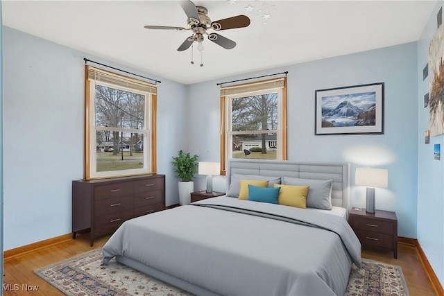 bedroom with light hardwood / wood-style flooring and ceiling fan