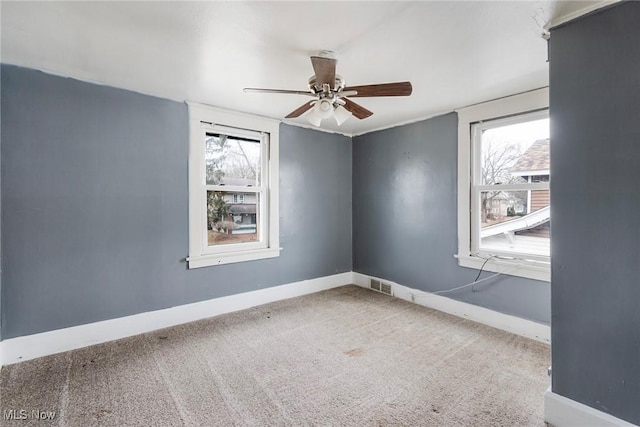 empty room featuring ceiling fan and carpet