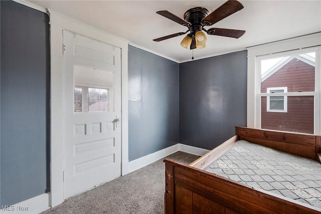 bedroom with multiple windows, crown molding, light colored carpet, and ceiling fan