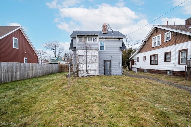 rear view of house featuring a lawn