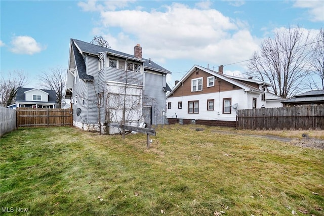 rear view of house featuring a yard