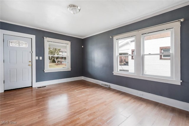 entryway with crown molding and light wood-type flooring