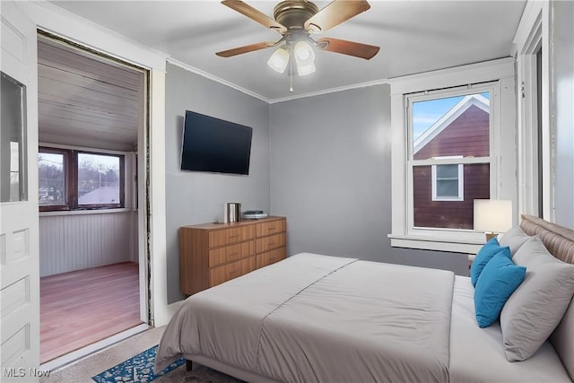 bedroom featuring multiple windows, ornamental molding, and ceiling fan