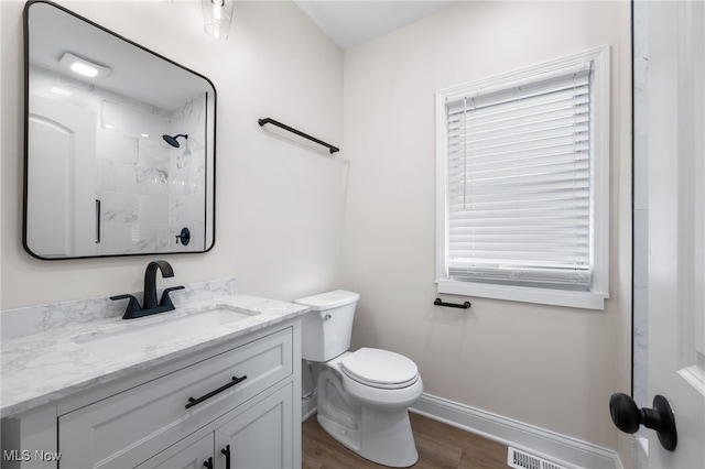 bathroom with walk in shower, vanity, toilet, and wood-type flooring