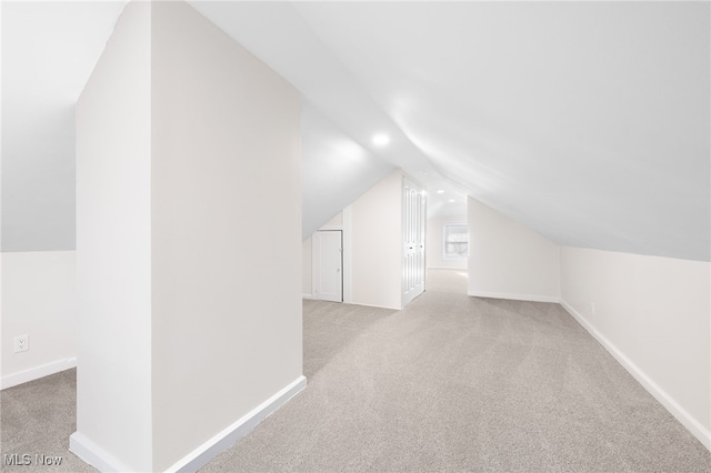 bonus room featuring vaulted ceiling and light carpet