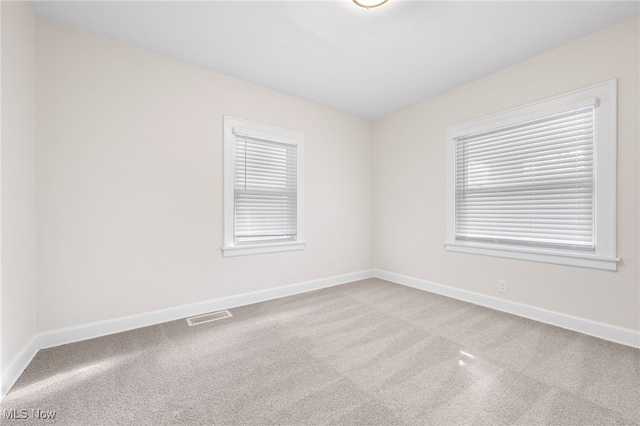 unfurnished room featuring light colored carpet