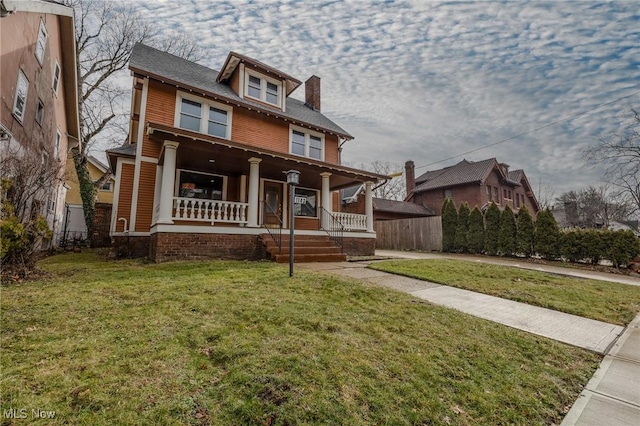 view of front of property featuring a front yard and covered porch