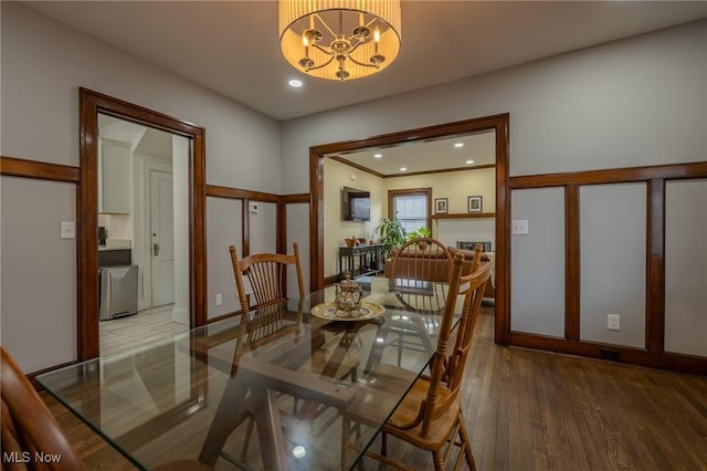 dining area featuring wood-type flooring and a notable chandelier