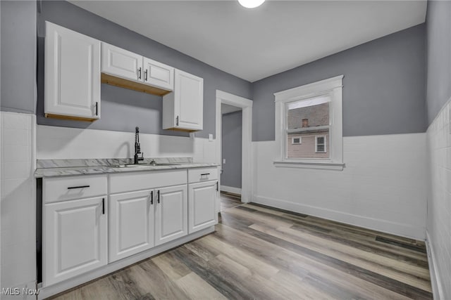 kitchen featuring white cabinetry, sink, and light wood-type flooring