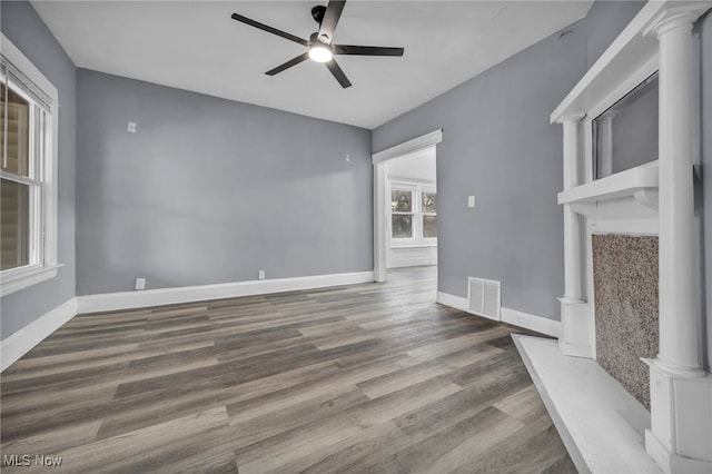 unfurnished living room featuring wood-type flooring, decorative columns, and ceiling fan