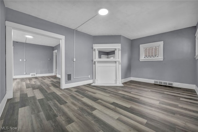 unfurnished living room with dark wood-type flooring