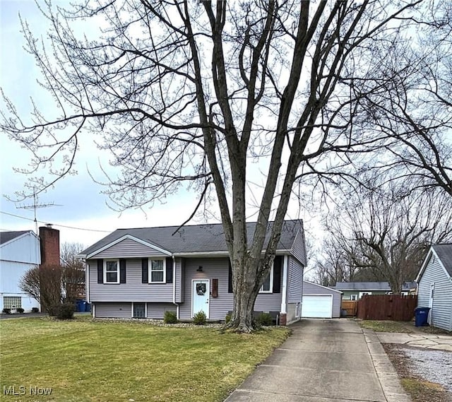 view of front of house featuring a garage, an outdoor structure, and a front lawn