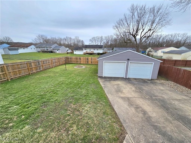 view of yard with an outbuilding, a garage, and a fire pit