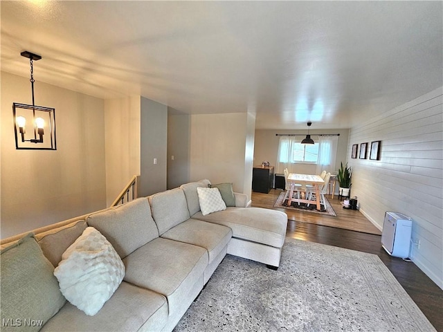 living room with a notable chandelier and dark wood-type flooring