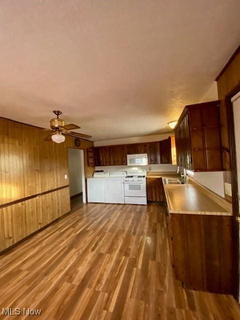 kitchen with wooden walls, white appliances, and dark hardwood / wood-style floors