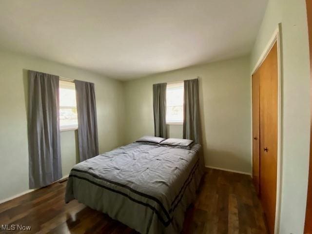 bedroom with dark hardwood / wood-style flooring