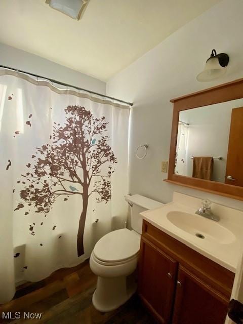 bathroom featuring hardwood / wood-style flooring, vanity, lofted ceiling, and toilet