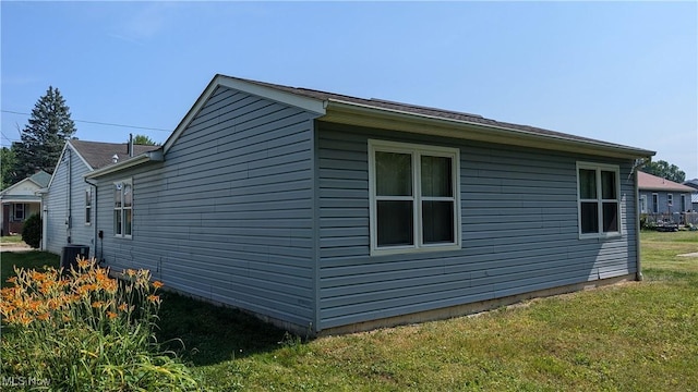 view of home's exterior with a yard and central AC