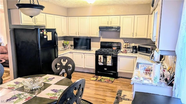 kitchen featuring extractor fan, pendant lighting, white cabinets, and black appliances