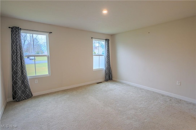 spare room featuring light carpet