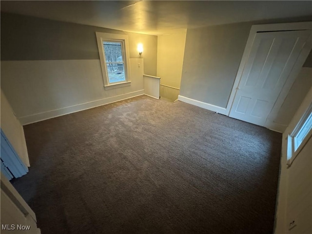 unfurnished room with dark colored carpet