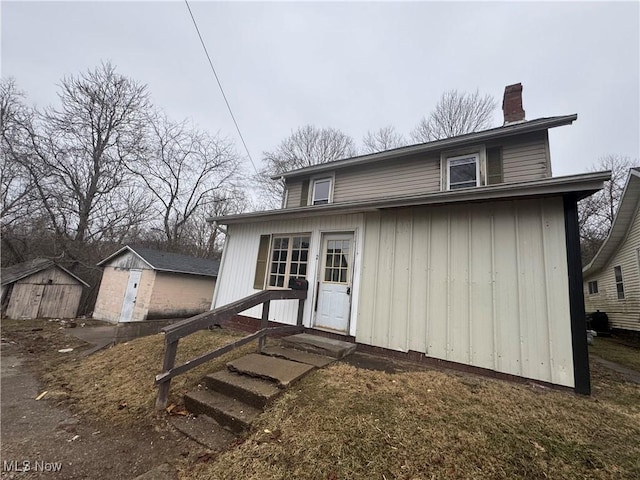 back of property with a storage shed