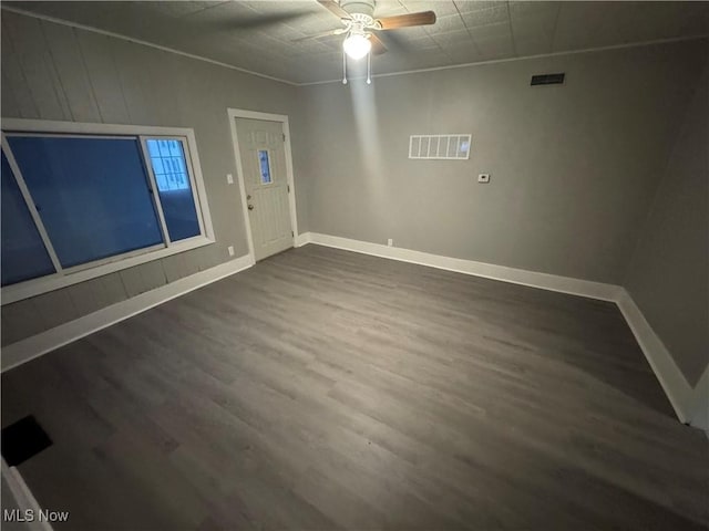 empty room with dark hardwood / wood-style floors and ceiling fan