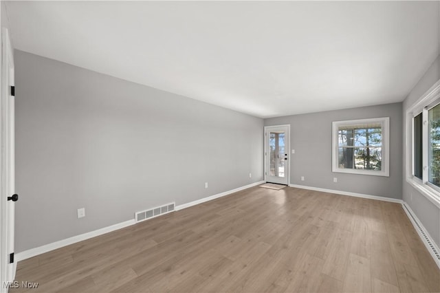 spare room with a baseboard radiator and light hardwood / wood-style floors