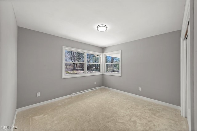 carpeted empty room with a baseboard radiator