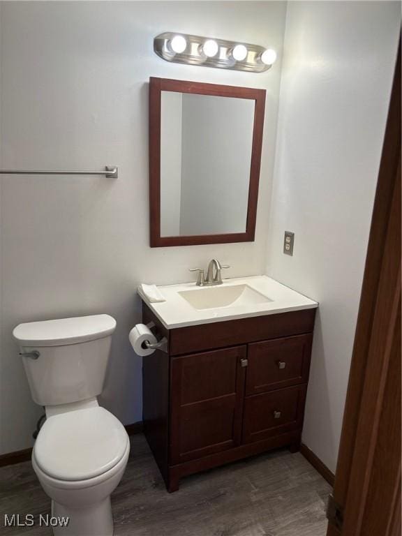 bathroom featuring vanity, wood-type flooring, and toilet