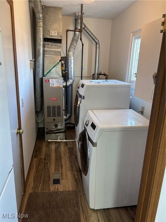 laundry room with dark wood-type flooring and independent washer and dryer