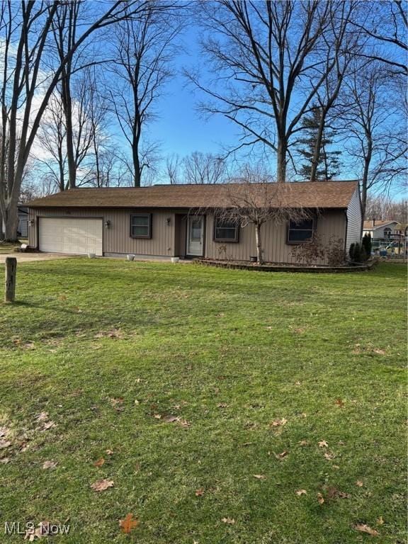 ranch-style home with a garage and a front lawn