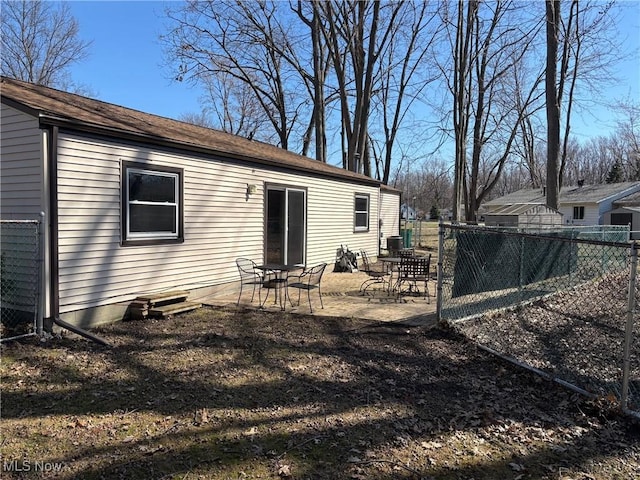 rear view of property featuring a patio and a fenced backyard