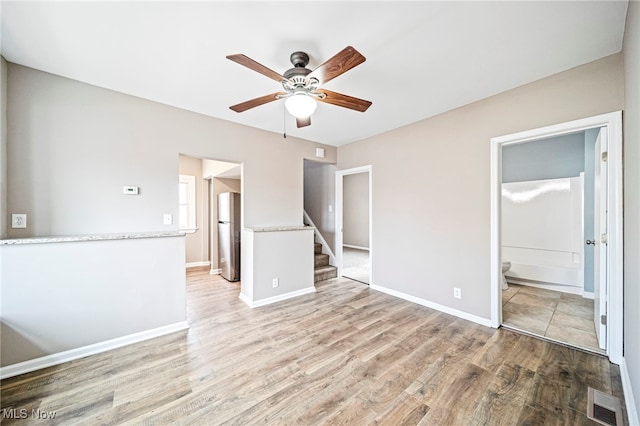 unfurnished living room featuring ceiling fan and light wood-type flooring