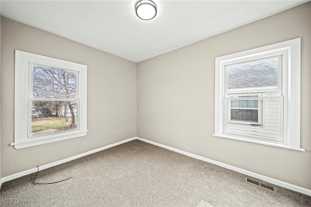 spare room featuring a healthy amount of sunlight and carpet