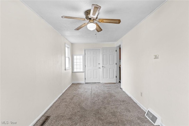 carpeted spare room with ceiling fan