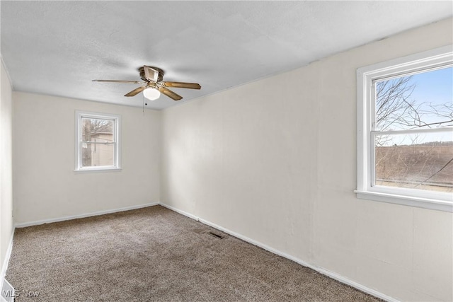 carpeted spare room with a textured ceiling and ceiling fan