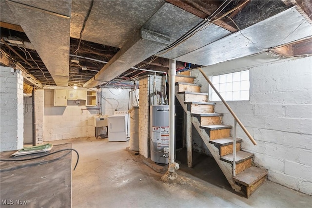 basement with water heater and washer / dryer