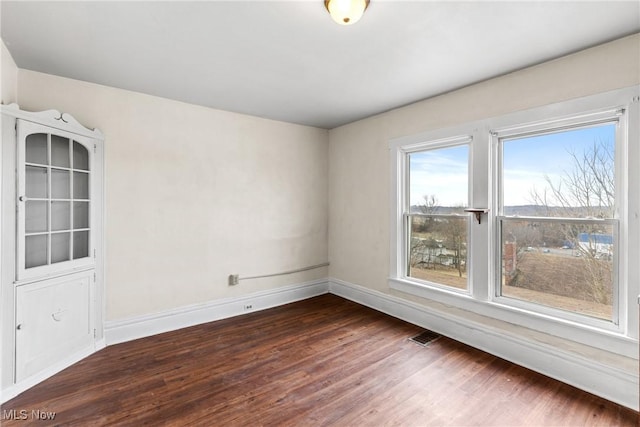 unfurnished room with dark hardwood / wood-style flooring