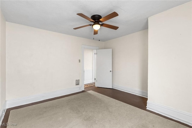 unfurnished room with ceiling fan and dark hardwood / wood-style flooring